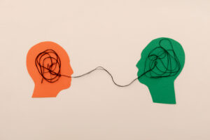 Two human head silhouettes Connected by tangled Thread, Symbolizing Communication and Understanding